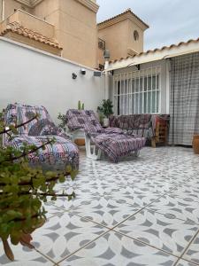 un patio con sofás y sillas en un edificio en Casa de la playa, en Torrevieja