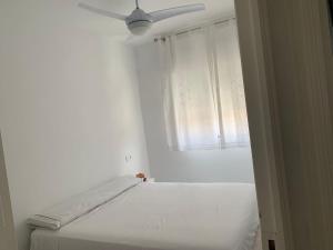 a white room with a bed and a window at Casa de la playa in Torrevieja