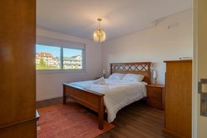 um quarto com uma cama e uma janela em Apto com varanda gourmet em Canela CBL307 em Canela