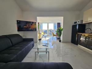 sala de estar con sofá y mesa de cristal en The Luxury Apartments - Villa Havana, en Novalja