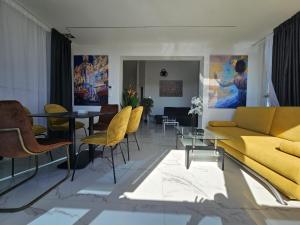 a living room with a yellow couch and a table at The Luxury Apartments - Villa Havana in Novalja
