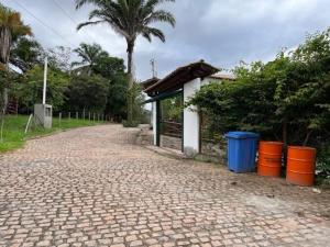 a cobblestone road with a building and palm trees at Vivendas do Serrano Apart105 Lençois in Lençóis