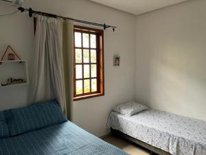 a bedroom with two beds and a window at Apartamento em Lençóis, Cond. Vivendas do Serrano 105 in Lençóis