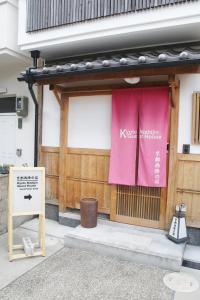 京都市にある京都西陣の宿の側面にピンクの旗を掲げた建物