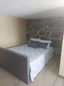 的住宿－Casa dos Devezas，一间卧室配有一张石墙床