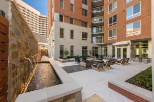 an outdoor patio with a water fountain in front of a building at Stunning City view - Condo at Crystal City with Rooftop in Arlington