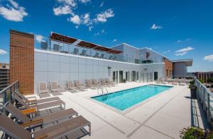 a swimming pool on the roof of a building with chairs at Stunning City view - Condo at Crystal City with Rooftop in Arlington