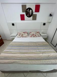 a bedroom with a large bed with two pillows at Flat Cavalinho Branco - Ap 516 in Águas de Lindóia +57 photos