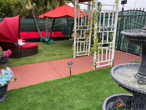 un giardino con divano rosso e altalena di Art Gardens Wynwood concept a Miami