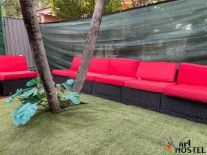 eine rote Couch auf einer Terrasse mit Palmen in der Unterkunft Art Gardens Wynwood concept in Miami