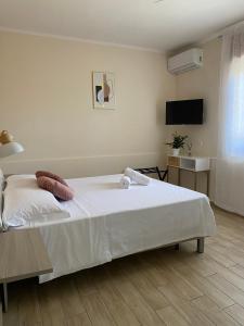 - une chambre avec un lit blanc et une télévision dans l'établissement Pompeii 22 Apartment, à Pompéi