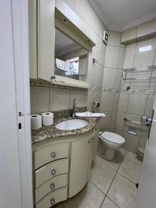 a bathroom with a sink and a toilet at Hotel Cavalinho Branco - Apartamento 516 in Águas de Lindóia