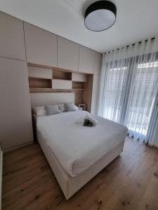 um quarto com uma grande cama branca com lençóis brancos em Citylux Grand Apartment em Zagreb