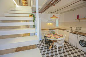 a kitchen and dining room with a table and stairs at Frida Salou ONLY FAMILIES in Salou