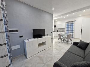 a living room with a tv and a couch and a table at La Maddalena Holiday Home in La Maddalena