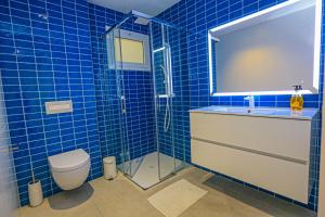 a blue tiled bathroom with a toilet and a shower at Frida Salou ONLY FAMILIES in Salou