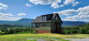 a house on top of a hill with mountains in the background at Hunters Haven in Luray