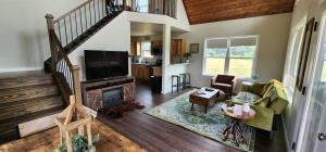 a living room with a staircase and a tv at Hunters Haven in Luray