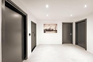 einen leeren Flur mit zwei Türen und einem Gemälde an der Wand in der Unterkunft HH 06 Modernes Apartment am Winterhuder Marktplatz in Hamburg