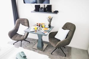 a dining room with two chairs and a table at HH 06 Modernes Apartment am Winterhuder Marktplatz in Hamburg