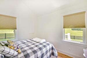 ein Schlafzimmer mit einem Bett und zwei Fenstern in der Unterkunft Modern Altavista Farmhouse with Countryside Views in Altavista