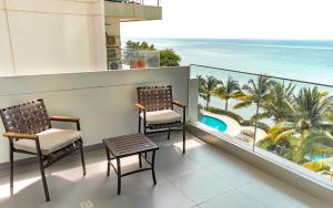 balcón con 2 sillas y vistas al océano en P2 Poseidon 5 Stars Ocean View Prestigioso Apartamento 2 Dormitorios, en Manta