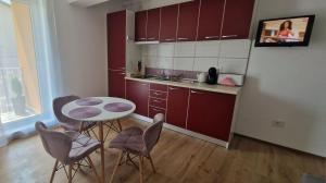 a kitchen with a table and chairs in a room at Ap CALAS , No1 2B Etajul 1, AC, Free Parking in Râşnov