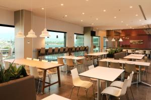 a restaurant with tables and chairs and windows at City Express by Marriott Monterrey Universidad in Monterrey