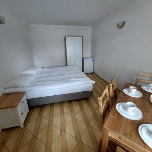 een slaapkamer met een bed en een tafel met 2 stoelen bij Pensjonat Beata in Jastrzębia Góra