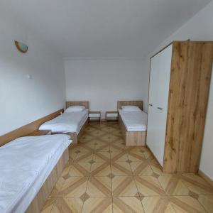a room with three beds and a cabinet at Pensjonat Beata in Jastrzębia Góra