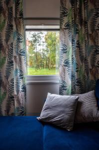 a pillow sitting on a bed in front of a window at Domki w górach in Międzylesie