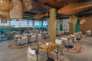 a restaurant with tables and chairs and a view of the ocean at Le Mersenne Zanzibar, Autograph Collection in Michamvi