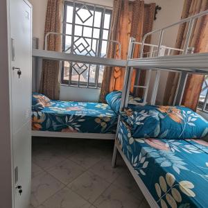 a room with two bunk beds and a window at Mufasa city Hostel and Apartments in Arusha