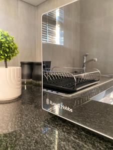 Urban & Comfortable Loft apartment in Mthatha في امتاتا: طاولة مطبخ مع حوض في جهاز زجاجي