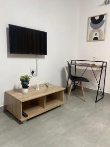 a living room with a table and a television on a wall at Urban & Comfortable Loft apartment in Mthatha in Mthatha
