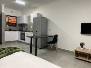 Urban & Comfortable Loft apartment in Mthatha في امتاتا: مطبخ مع طاولة وكرسي في الغرفة