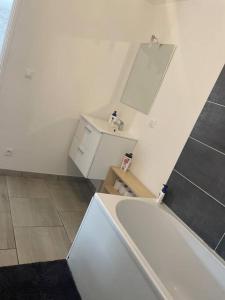 a white bathroom with a sink and a mirror at L'eSPAce détente in Beuvry