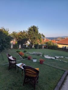 a backyard with two chairs and a table in the grass at Bajka in Valjevo