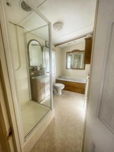 bagno con servizi igienici, lavandino e specchio di Cosy Cottage Caravan a Ashington
