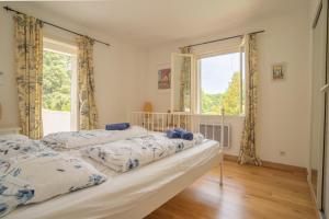 2 camas en una habitación con ventana en Maison des lavandes, en Saint-Cannat