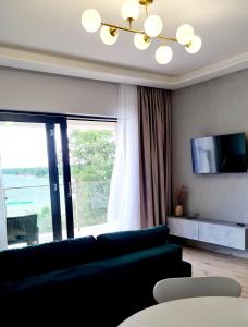 un soggiorno con divano e una grande finestra di Apartamenty Horizon Sunrise Boszkowo a Boszkowo