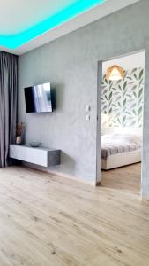 - une chambre avec un lit et une télévision murale dans l'établissement Apartamenty Horizon Sunrise Boszkowo, à Boszkowo