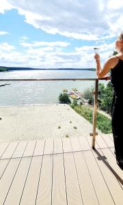 une femme debout sur une terrasse donnant sur la plage dans l'établissement Apartamenty Horizon Sunrise Boszkowo, à Boszkowo