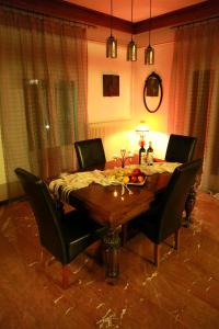 einen Esstisch mit schwarzen Stühlen und einem Tisch in der Unterkunft Edem House in Volos