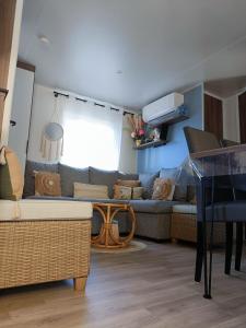 a living room with a couch and a table at mobil-home neuf 4-6 places camping Siblu les viviers in Lège-Cap-Ferret