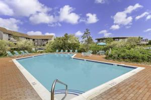 AmagansettUnit 821 Ocean Colony Beach的一个带椅子的大型游泳池和一栋建筑