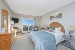 AmagansettUnit 821 Ocean Colony Beach的一间卧室，配有一张床、一张书桌和一台电视