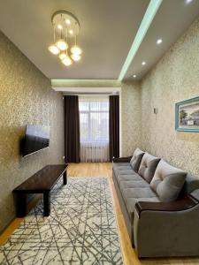 a living room with a couch and a tv at Dushanbe City View Apartment in Dushanbe