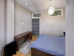 a bedroom with a desk and a bed and a table at Dushanbe City View Apartment in Dushanbe