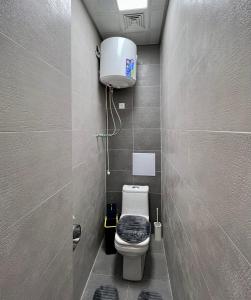 a small bathroom with a toilet and a water tank at Dushanbe City View Apartment in Dushanbe